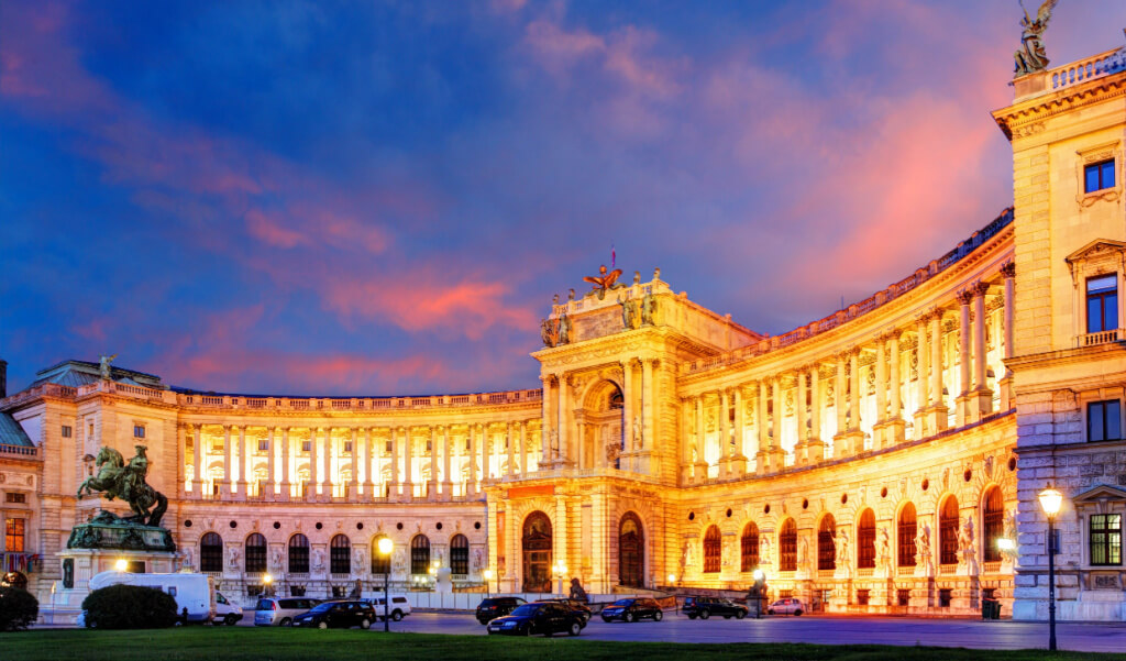 Vienna Hofburg Imperial Palace lit with lights at night .