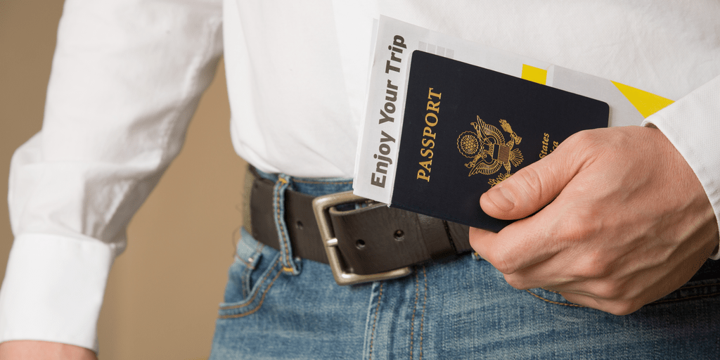 detail of man holding passport at waist level 